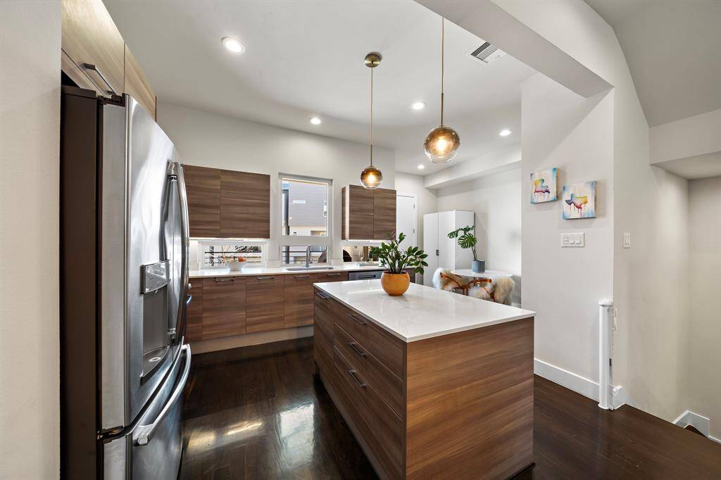 The sleek, contemporary kitchen features stainless steel appliances and a gas range, all highlighted by a modern backsplash, ideal for casual meals and entertaining.