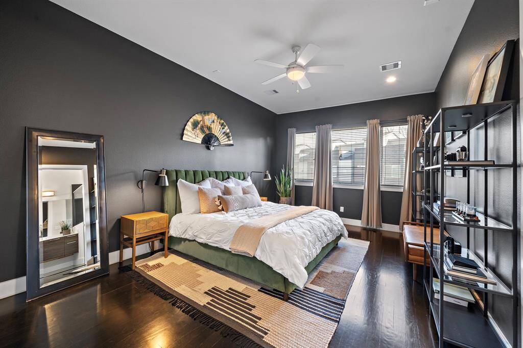 The primary bedroom offers an expansive layout with space for a cozy sitting area or personal workspace. Large windows fill the room with natural light, while a spacious walk-in closet and refined finishes create a luxurious and serene retreat.