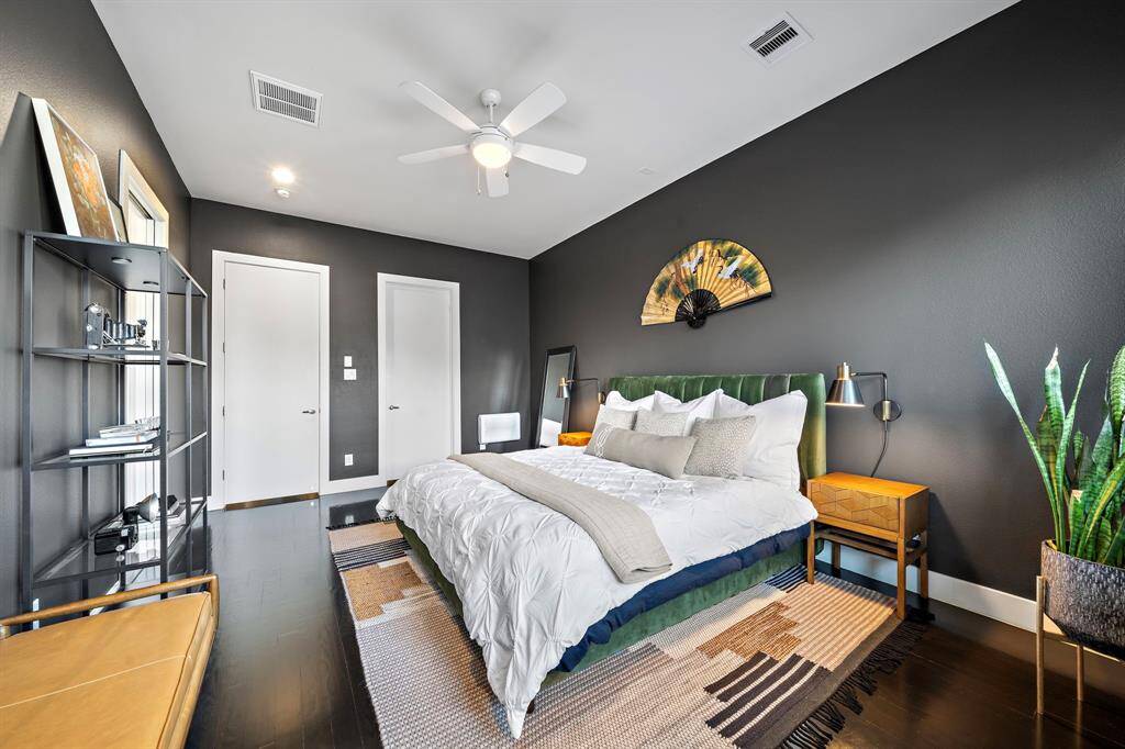 Designed for relaxation, this contemporary bedroom features sleek flooring and a chic ceiling fan. The room provides ample space for a cozy sitting area and boasts a large walk-in closet. Ideal for unwinding, its sophisticated accents create a serene retreat.
