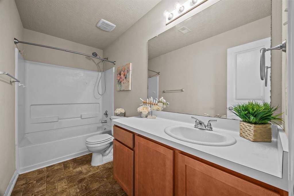 Spacious hall bathroom featuring a tub/shower combo and an expansive vanity.