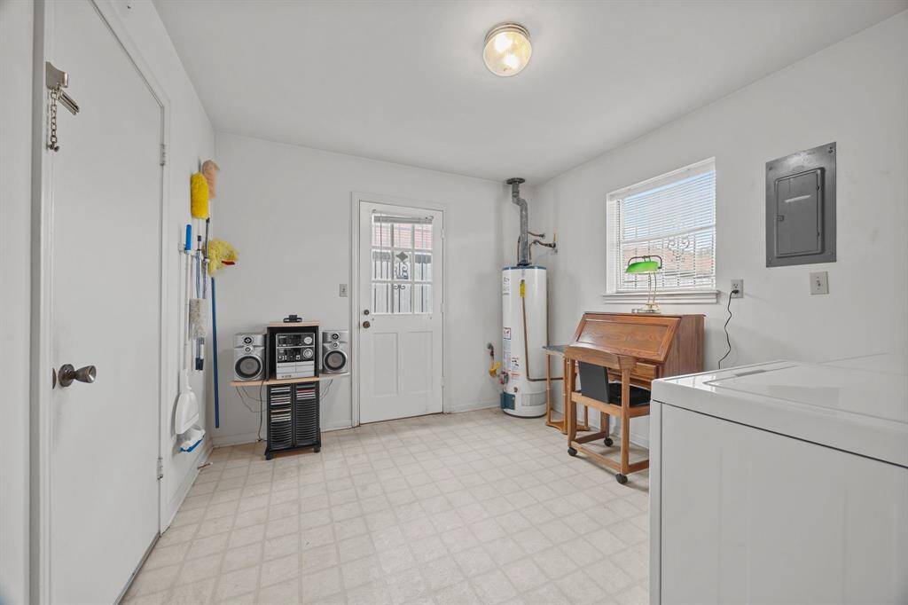 Bright Utility Room has plenty of storage space. Features a window for natural light, a door to the outside, and an organized cleaning supply area.