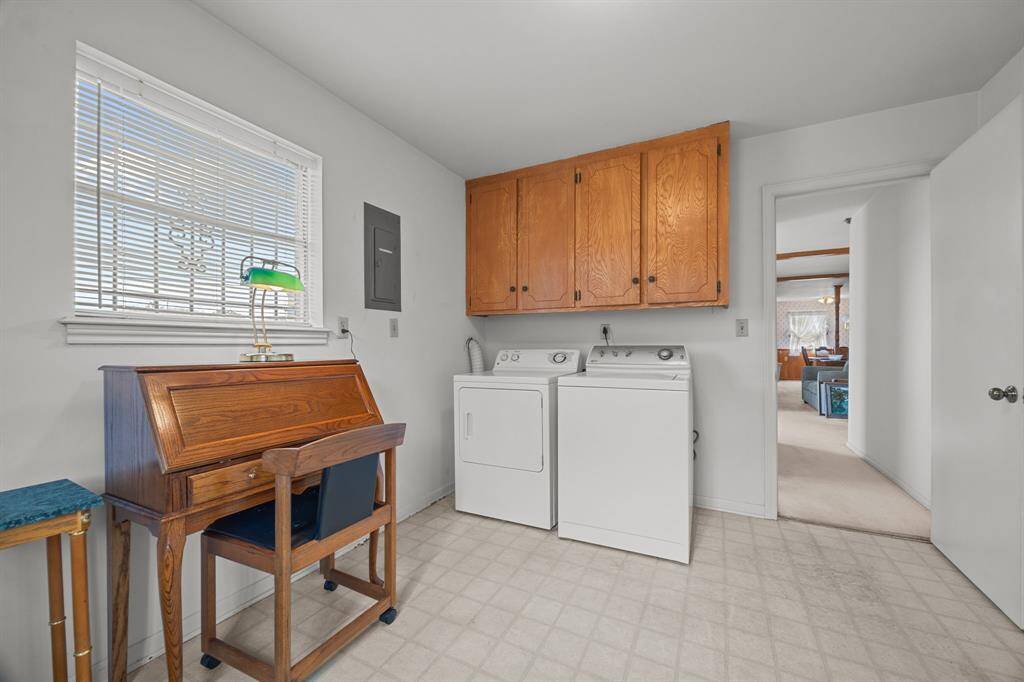 Oversized Laundry Room with space for a full-sized washer and dryer. Wooden storage cabinets above. Opens into the Family Room.