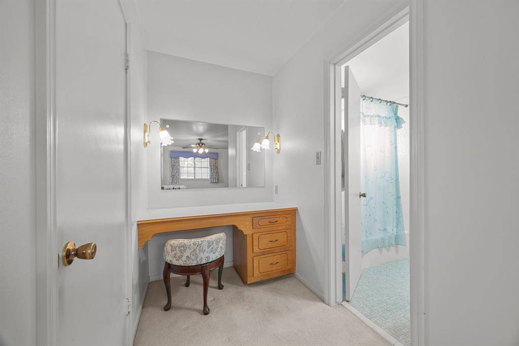 Cozy dressing area with a built-in vanity and mirror. The space is adjacent to the Primary Bathroom with a Tub/Shower combination.