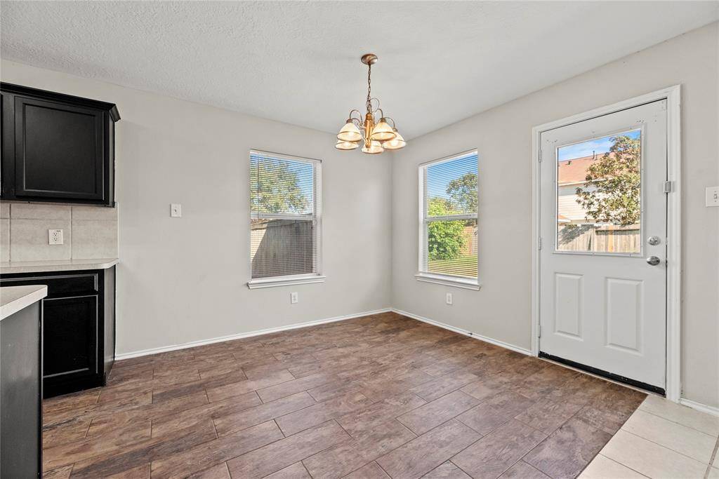 The breakfast room is perfect for a full-sized table and offers easy care tile flooring, large bright windows, an overhead chandelier with easy access to the backyard.