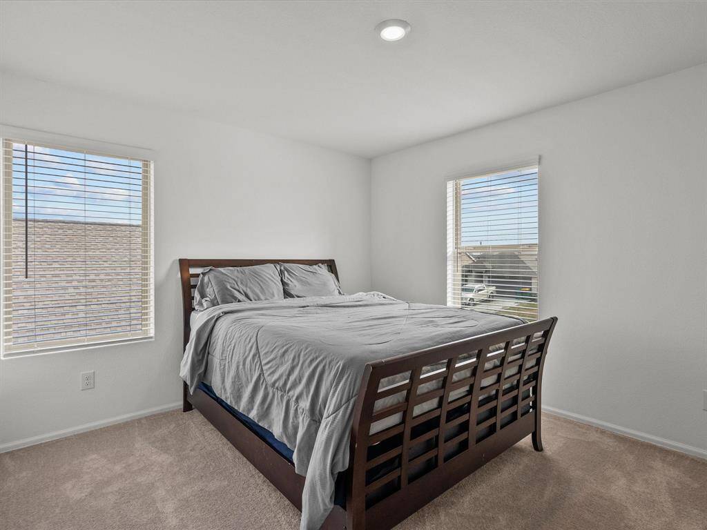 This cozy bedroom provides flexibility for use as a guest room or additional workspace upstairs.