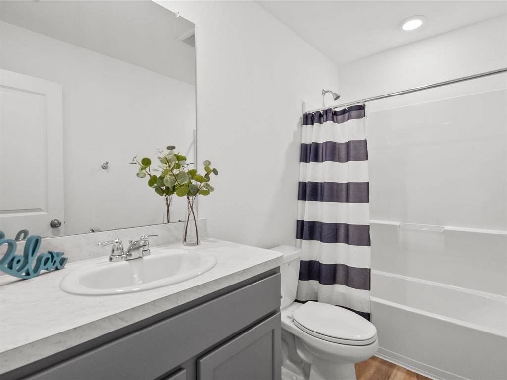 A clean and stylish guest bathroom with modern finishes and a shower/tub combo.