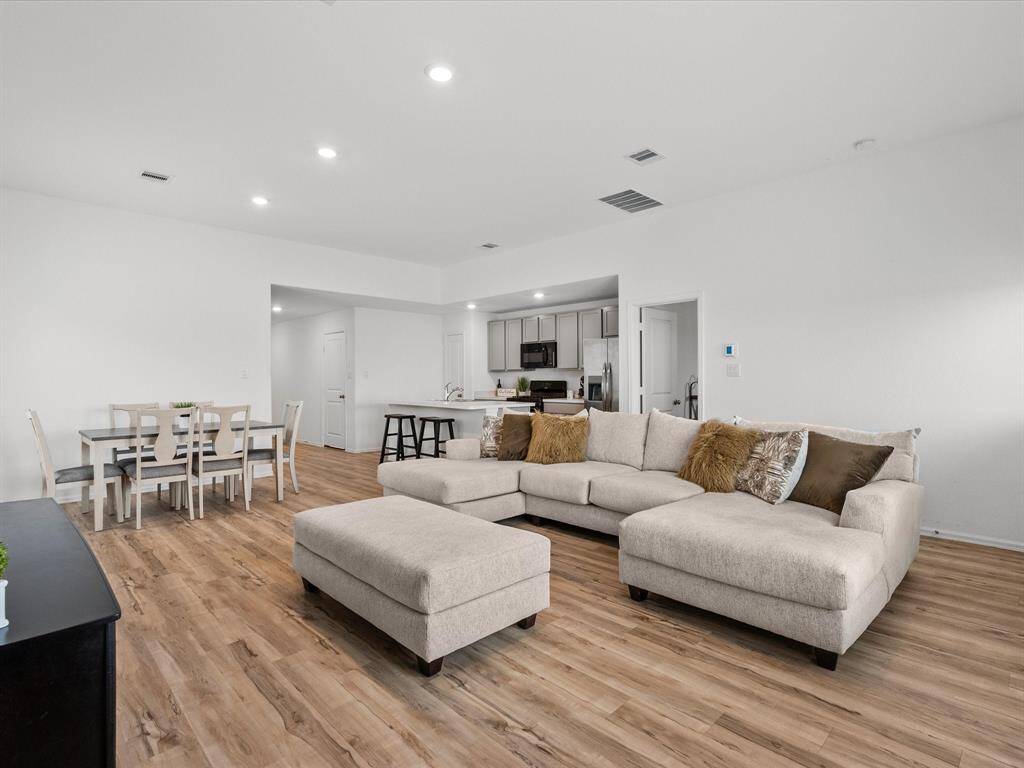 A bright, airy living room with a seamless flow to the kitchen and dining area, making entertaining effortless.