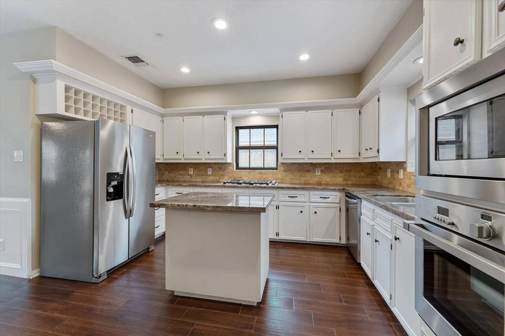 The kitchen features stainless appliances, gas cooking, wine storage, island and recessed lighting.