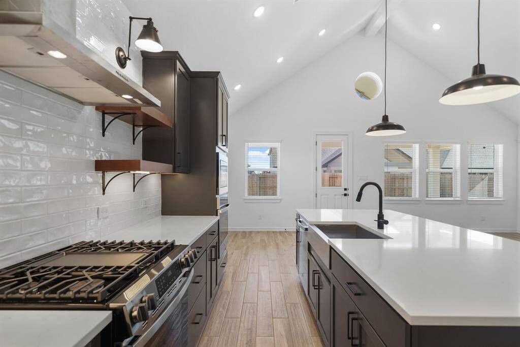 Stunning kitchen with quartz countertops, floating shelves, and pendant lighting (*Photo not of actual home and used for illustration purposes only.)