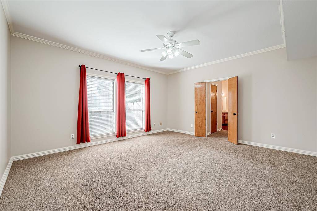 The primary bedroom is designed for comfort and relaxation, featuring large windows that fill the room with natural light.