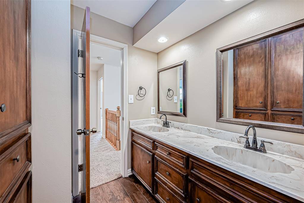 Upstairs bathroom features double vanity with beautiful framed mirrors and updated countertops.