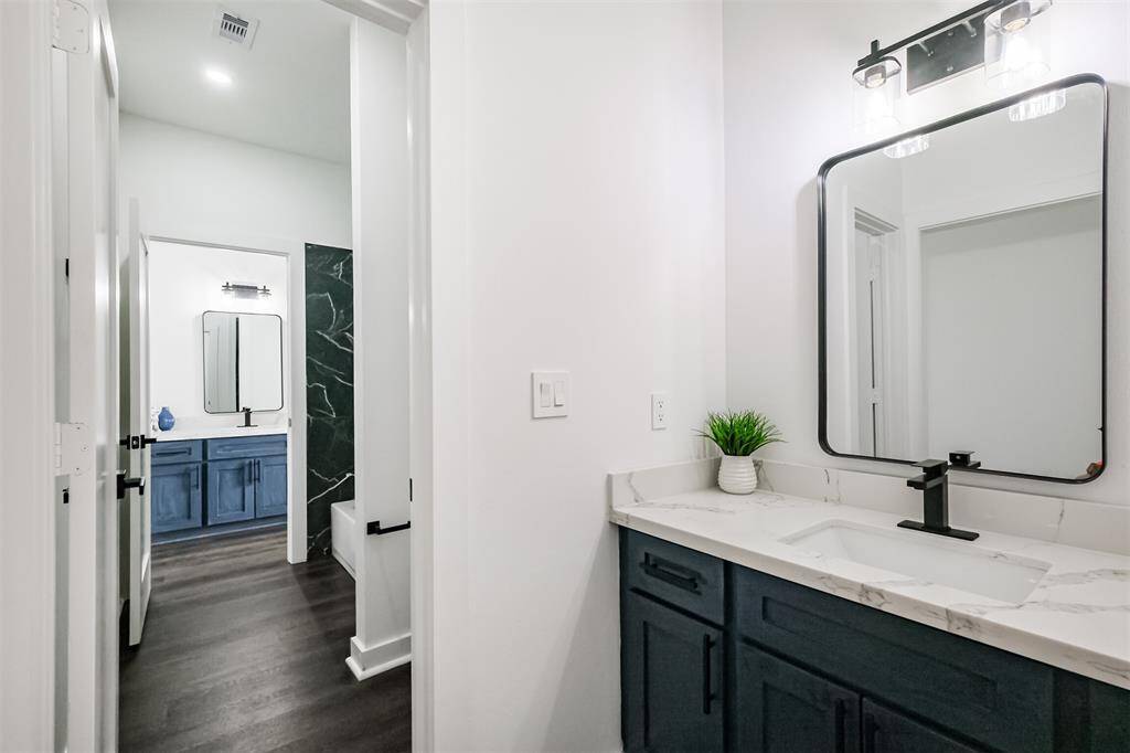 This bathroom features a modern shower with elegant black and white marble tile, providing a luxurious and sophisticated look. The shower includes a built-in niche for added convenience.