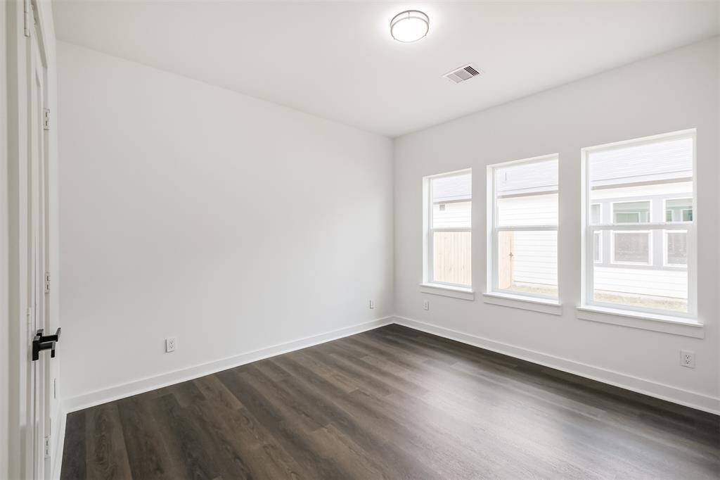 This is a laundry room with hookups for a washer and dryer. It features a white shelf for storage and a clean, minimalistic design.