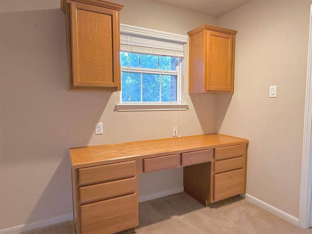Solid oak wood built-in desk providing ample space for work or study, including drawers and shelving for optimal organization.
