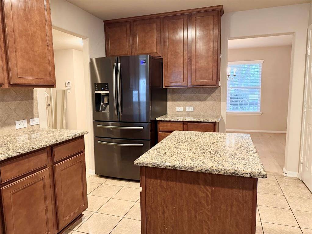 Modern kitchen equipped with stainless steel appliances, granite countertops, and a central island, ideal for culinary enthusiasts