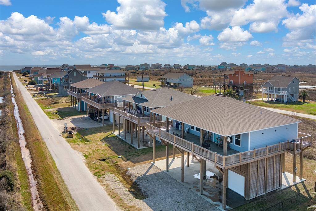 Beachside home has a full-sized garage, 15-ft long tiki bar, picnic table, and partially shaded deck.