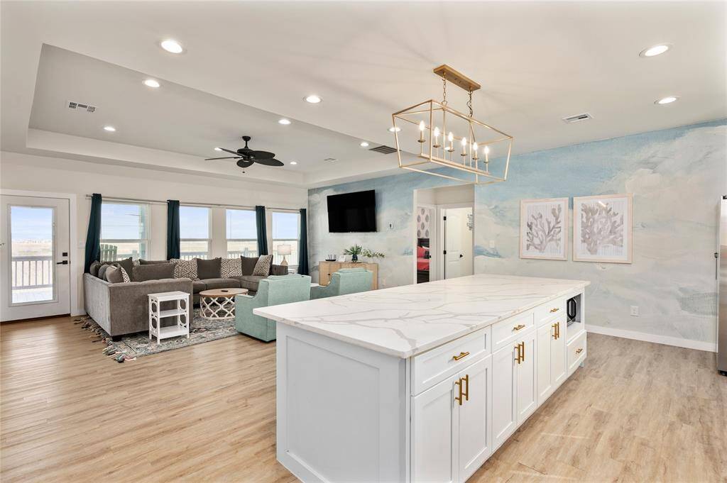 The living room and kitchen are bathed in natural light and features a trayed ceiling with ceiling fan. The property has LVP throughout the common areas and bedrooms.