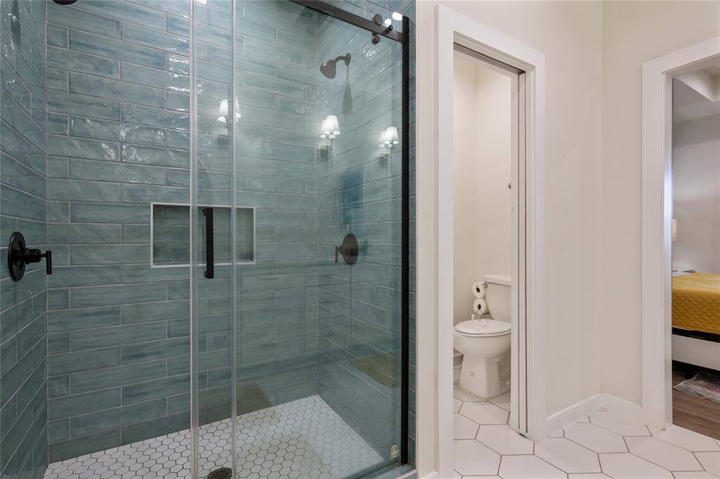 Check out this gorgeous green floor-to-ceiling tiled shower and separate toilet closet.
