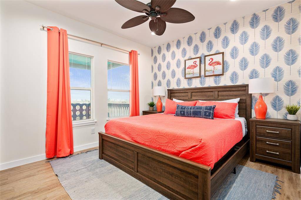 Secondary bedroom features a king bed, wall mural, and a wall-mounted TV.