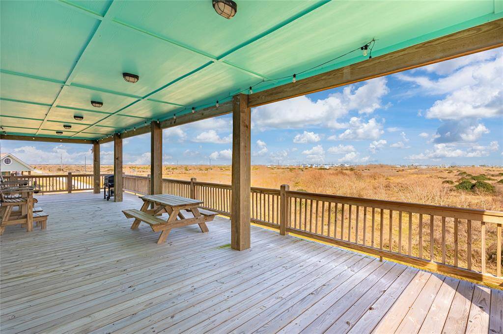 Deck overlooks large, undeveloped tract of land, providing a peaceful view of the Gulf.