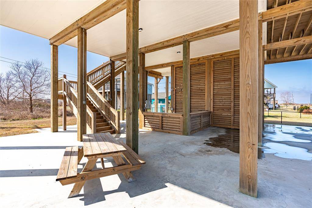 The ground floor is ready to entertain a crowd with its tiki bar with string lights, picnic table, sand shower, and garage for storing all the ingredients you need for fun at the beach.