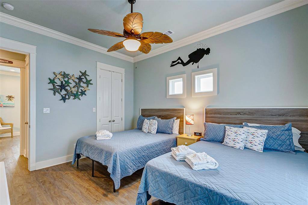 Bedroom has high ceilings, ceiling fan, and a wall-mounted TV.