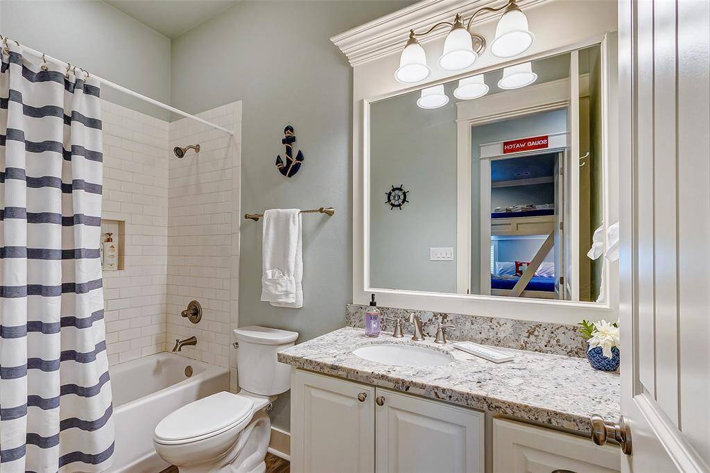 The granite countertops and LVP flooring continue into the hallway bathroom.