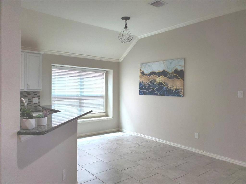 This living room features a spacious and modern design. It has a sleek fireplace, complemented by built-in shelves. Large windows provide ample natural light, and the ceiling fan adds comfort.