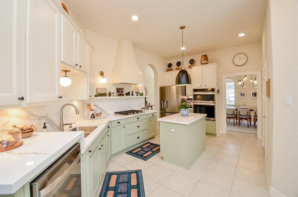 Beautifully updated kitchen (2023) includes new porcelain countertops, custom vent hood and new drawers by Natural Wood Carpentry.  Lower cabinet beneath the sink has a light that comes on automatically.