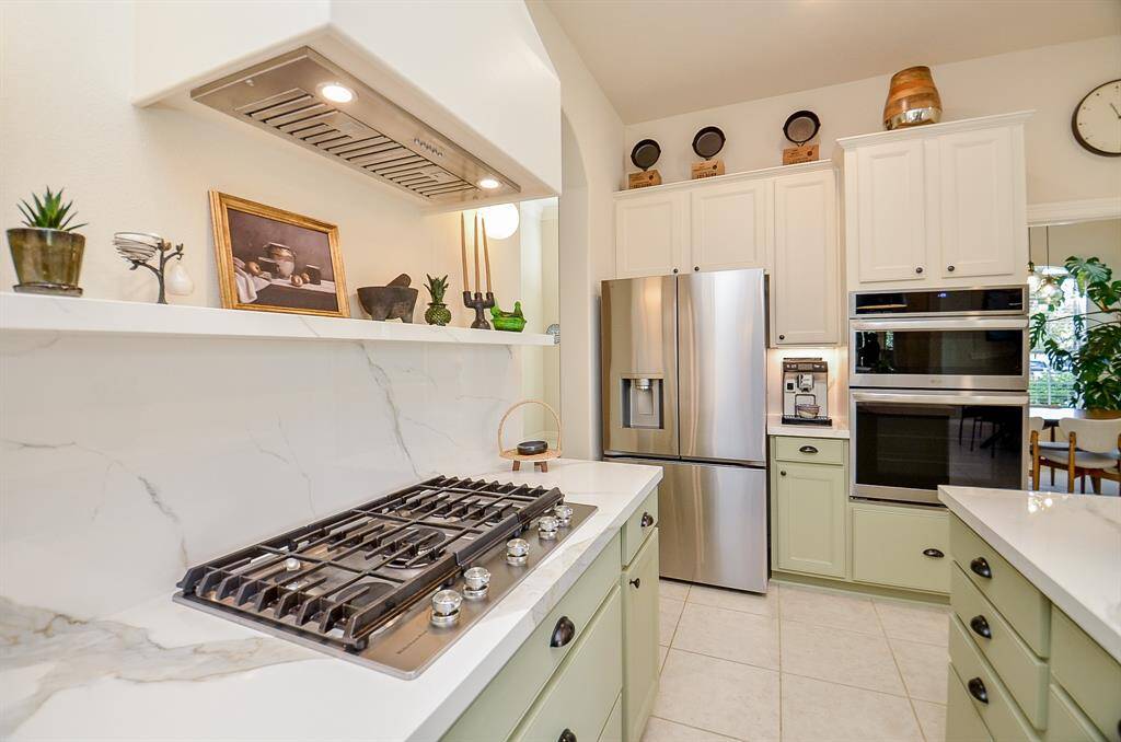 New 5 burner Kitchen Aid gas cooktop was added in 2023.  Cabinets are painted Sherwin Williams Sage.