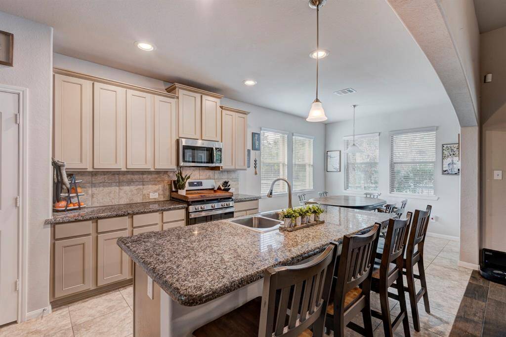 Kitchen offers tile flooring, Granite counter tops, Stainless Steel GE Appliances, 42 inch cabinets and an oversized island that doubles as a breakfast bar.