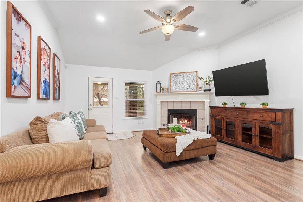 The inviting living room features a cozy fireplace. The elegant mantle and the soaring vaulted ceilings make this room spacious.