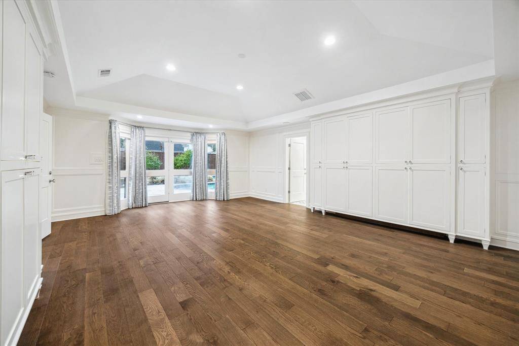 Primary bedroom is a welcome invitation to relax. Has doors that open to the backyard with pool.