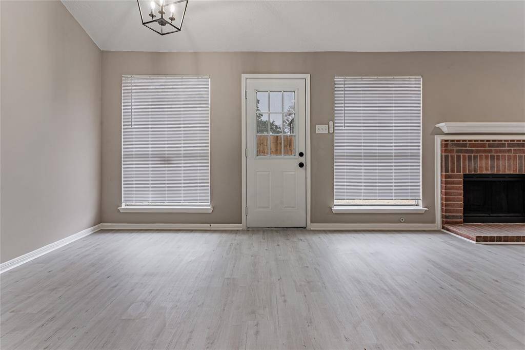Bright and inviting living area featuring large windows, elegant flooring, with a perfect fireplace to keep you cozy on chilly nights.