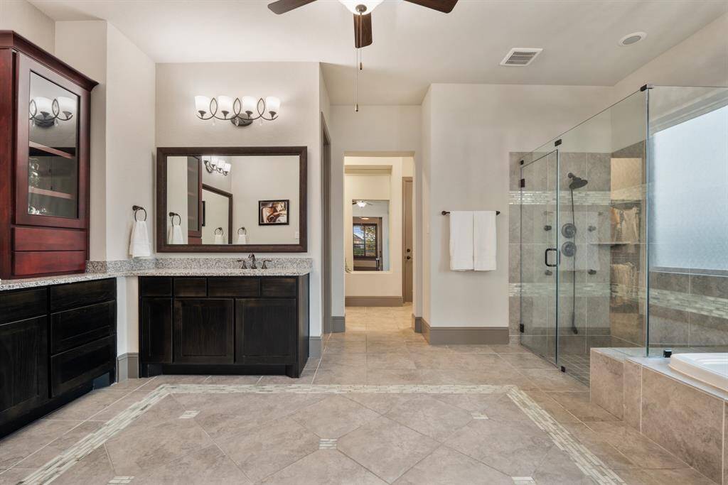The luxurious primary ensuite features dual vanities, a relaxing whirlpool tub, and a sleek frameless glass shower for a spa-like experience. A spacious walk-in closet adds convenience and ample storage.