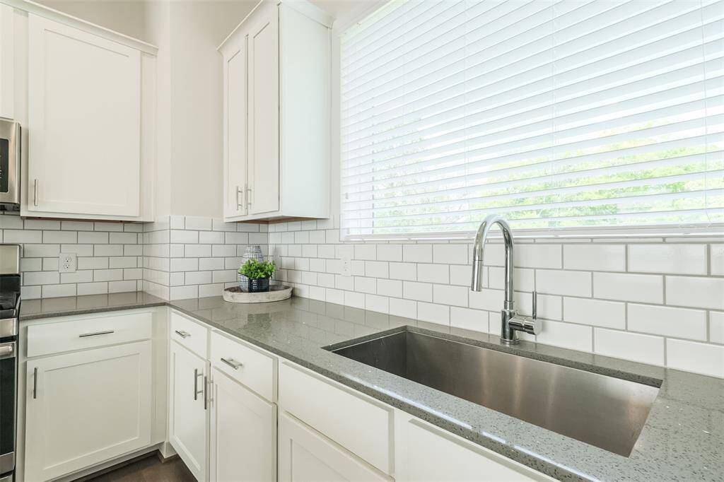 The large window provides a panoramic view of the outdoors, bringing in natural light and a calming ambiance as you whip up culinary delights. Let the stainless steel accents and picturesque window create the perfect backdrop for your gatherings over cocktails or leisurely breakfasts.