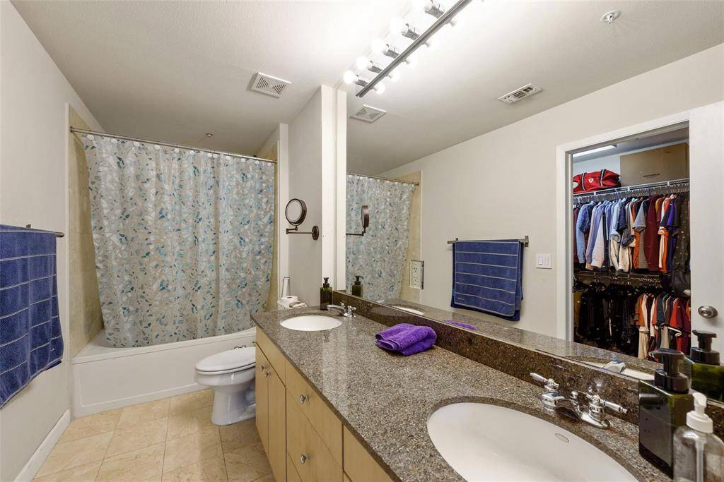 Another view of the primary bathroom with walk-in closet and soaking tub and shower.