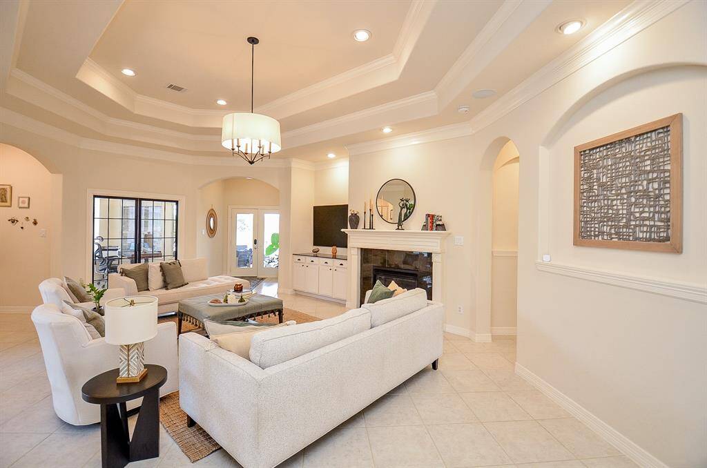 This elegant living room is the hub of the home.  The paint is Sherwin Williams Casa Blanca.  Note the graceful arches, and the fireplace with black marble surround.  The TV has its own nook with shelves below for components.