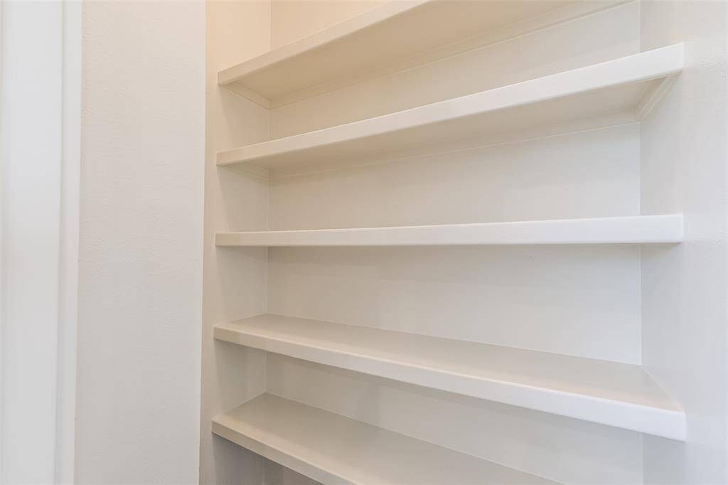 A walk-in pantry filled with plenty of shelving options which offer ample storage space for all your kitchen essentials.