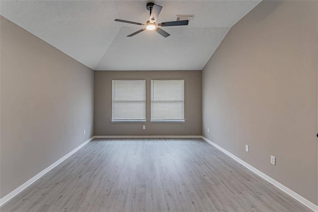 Spacious primary bedroom with modern flooring, neutral tones, and abundant natural light.