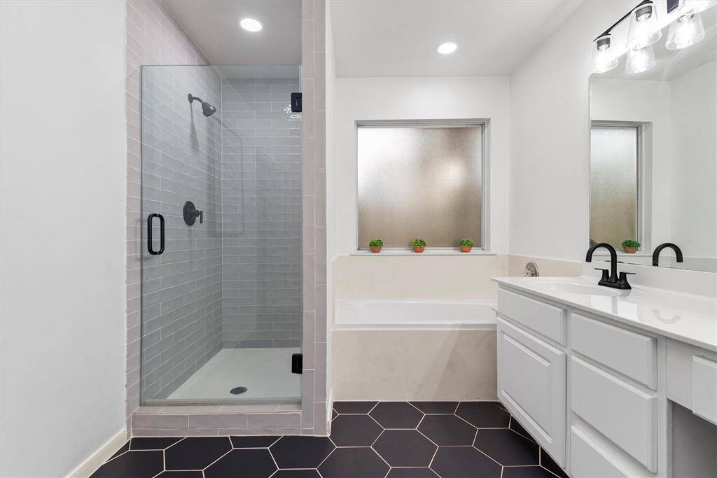 The updated stand alone shower is a statement piece as well.  The primary bathroom features a separate jetted tub, a stand alone shower, 2 vanity sinks, a water closet and a huge walk in closet.
