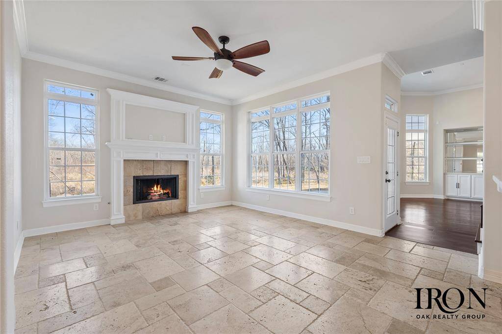 Bright and airy secondary living room with an open-concept design, seamlessly connecting to the kitchen and breakfast nook. The expansive windows, neutral palette, and elegant tile flooring create a fresh, welcoming ambiance, perfect for both everyday living and entertaining.