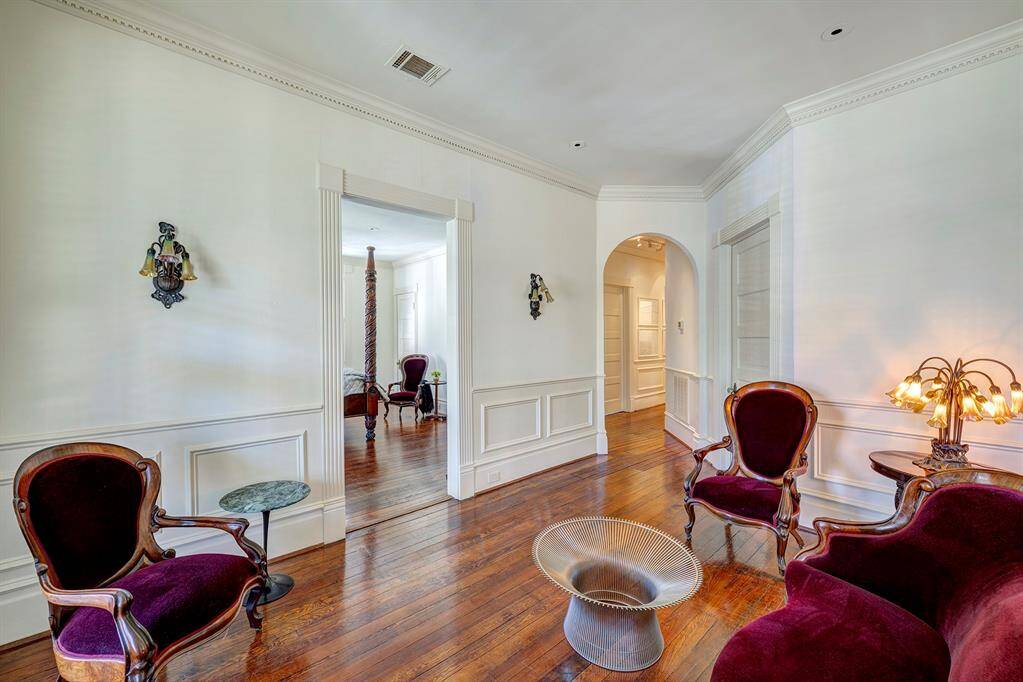 Another view of the landing with gleaming hardwood floors enhance the airy feel, creating a seamless and stylish connection between the bedrooms. Thoughtfully designed, this central hub provides easy access to all three upstairs bedrooms while serving as a charming transitional area. Perfectly balanced between form and function, the landing adds an elegant touch to the home's upper level.
