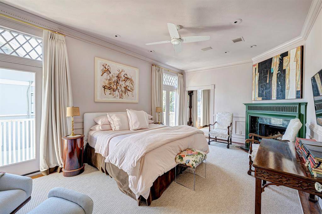 The primary bedroom is a luxurious retreat, bathed in natural light and offering breathtaking views of the backyard and sparkling pool. The elegant fireplace serves as a focal point, adding warmth and sophistication to the spacious layout. Large windows not only frame the stunning outdoor scenery but also fill the room with a serene ambiance.