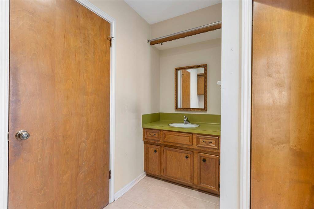 The oversized laundry room features wood cabinets and tile flooring.  Room for a refrigerator!