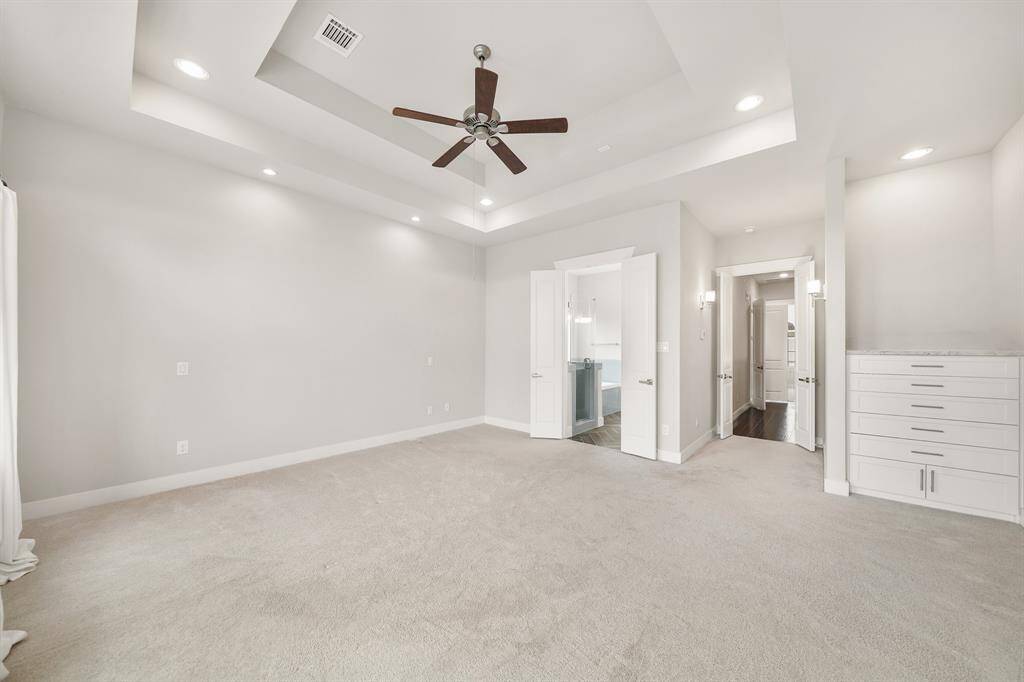 Accessible from the third floor corridor via double entry doors framed by sconce lighting, this beautiful owner's suite includes a quartz surfaced built-in wardrobe storage area.