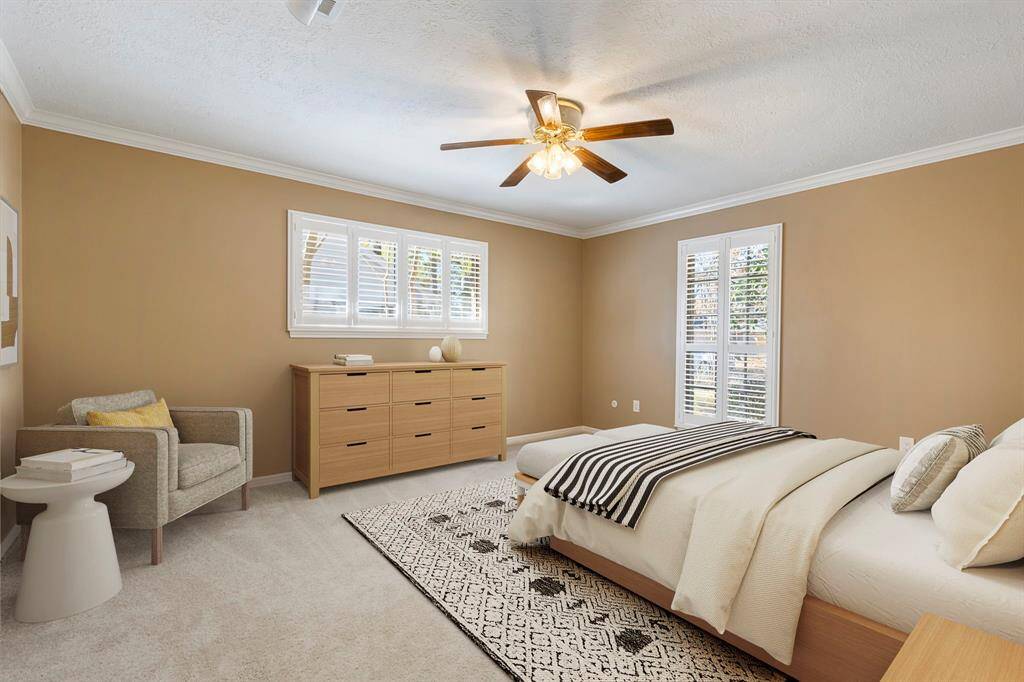 The primary bedroom is located on the 1st level with new carpet, crown moulding and fan.  *This image has been virtually staged.