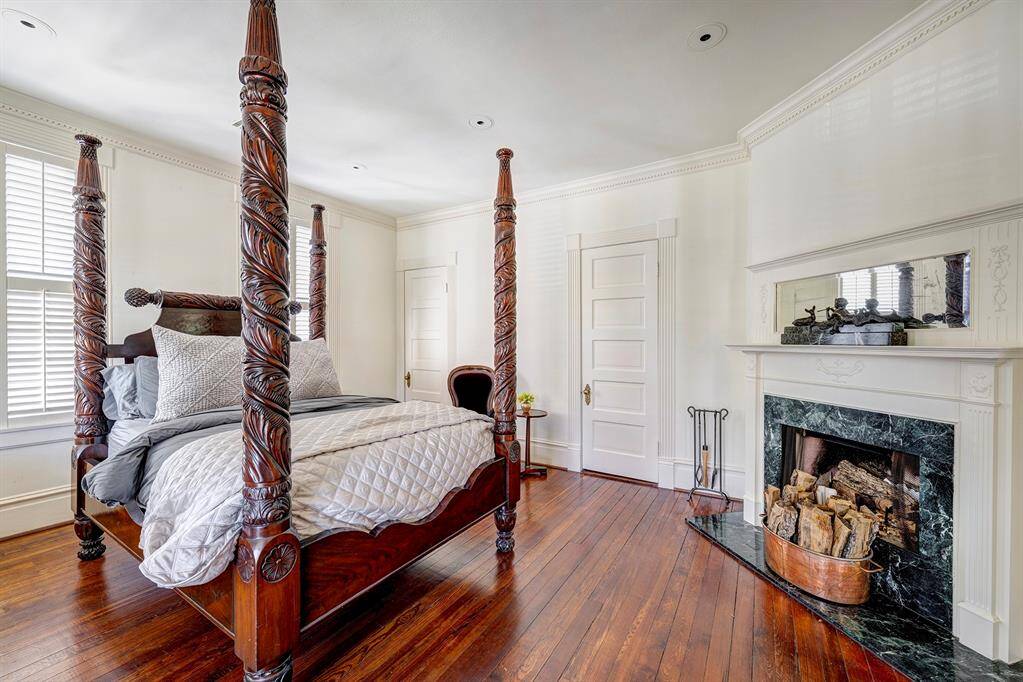 The secondary bedroom is a charming and well-appointed space featuring beautiful hardwood floors that add warmth and character. A cozy fireplace serves as a delightful centerpiece, creating a sense of comfort and elegance.