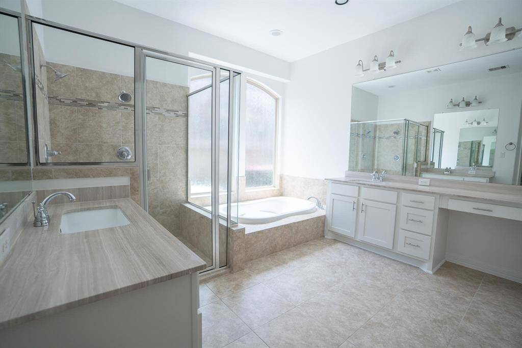 Spacious primary bathroom with shower and relaxing soaking tub