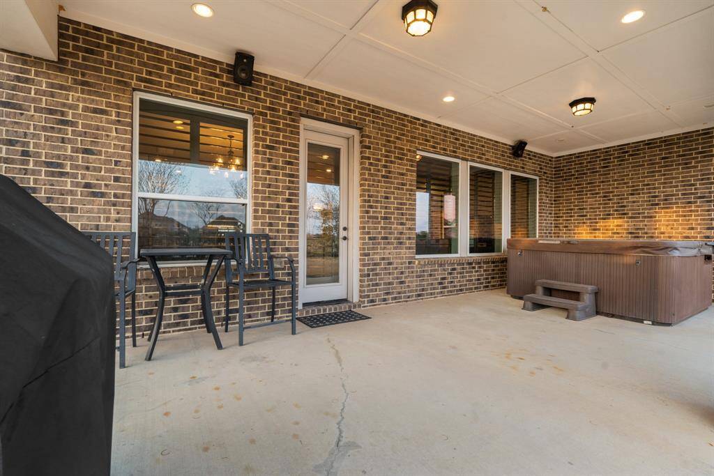 The generously sized covered patio offers a perfect outdoor retreat with stunning views of the backyard and lake. Designed for relaxation and entertaining, it seamlessly extends the home's living space into nature.